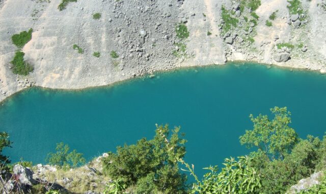 The turquoise water of the Blue Lake in its karst basin at Imotski